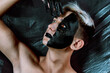 © Denis - Portrait of a young man with unusual makeup. The guy is posing without a T-shirt. Black paint on the face.