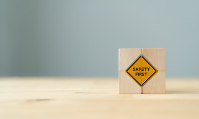 Safety symbols and first signs, work safety, caution work hazards, danger surveillance, zero accident concept on wooden cubes with beautiful  grey background and copy space. Safety banner..