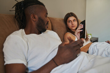 Wall Mural - Serious Caucasian female confiscating young male gadget