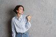 © Drobot Dean - Young brunette woman expressing surprise and pointing finger aside