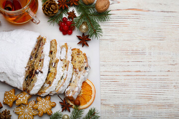 Wall Mural - Traditional Christmas Stollen with icing sugar on white wooden table, flat lay. Space for text