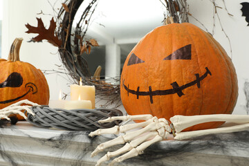 Wall Mural - Pumpkins with drawn spooky faces and burning candles on table. Halloween decor