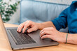 © KseniaJoyg - The hands of a young man on a laptop keyboard at home or in a cafe. Remote work or shopping online. Freelance and freedom.