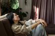 © Westend61 - Woman resting on sofa at home