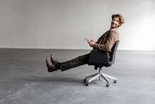 Smiling Businessman Sitting On Office Chair