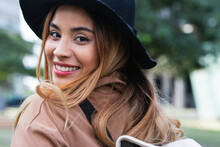Smiling Blond Woman Wearing Hat Looking Over Shoulder