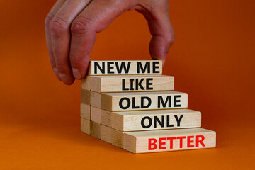 Better new me symbol. Wooden blocks with words 'new me like old me only better'. Beautiful orange background, copy space. Businessman hand. Business and better new me concept.