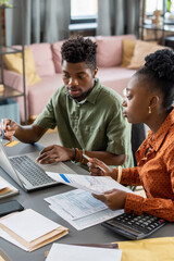 Aufkleber - Serious young African American couple sitting at table and entering bill data while filling tax form online