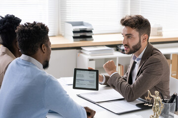Poster - Bearded investment manager showing data on tablet to young couple while telling about benefits of cash investments