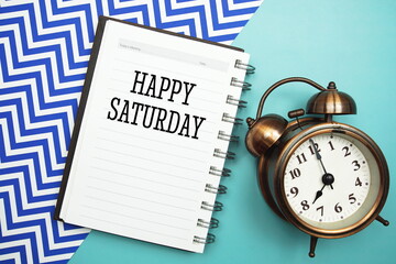 Wall Mural - happy saturday text and alarm clock on blue background
