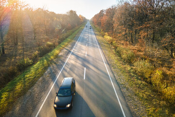 Canvas Print - Aerial view of intercity road with blurred fast driving car at sunset. Top view from drone of highway traffic in evening