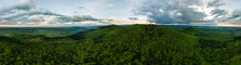 Aerial Wide Panoramic View Of Dark Mountain Hills Covered With Green Mixed Pine And Lush Forest In Evening