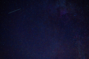 Wall Mural - shooting star meteorite comet on the background of a blue dark starry sky with galaxies and nebulae