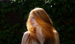 © ullision - Sensual sexy portrait of young beautiful redhead woman shakes her red hair outdoors in the sunlight with dark green ivy background