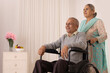 © IndiaPix - Senior woman moving her husband sitting on wheel chair