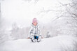 © Maria Moroz - little girl sitting on snow in park in winter