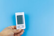 © olyasolodenko - Digital glucometer in female hand over a pastel blue background. Diabetes concept
