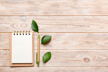 eco-friendly Empty notebook with pen and green leaf on Colored background for note