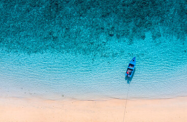Wall Mural - boat near the beach. blue water background from top view. summer seascape from air. aerial landscape