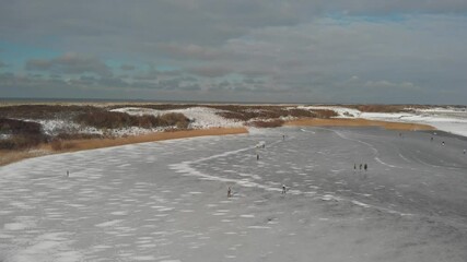 Wall Mural - people ice skating on a frozen lake during winter in the Netherlands