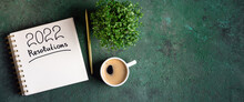 New Year Resolutions 2022 On Desk. 2022 New Year Resolutions On Green Background With Coffee Cup, Notebook And Plant. New Year Goals, Plan, Resolutions, Business Concept. Copy Space