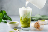 Fototapeta Desenie - Soy milk pouring in matcha ice tea. Healthy vegan drink