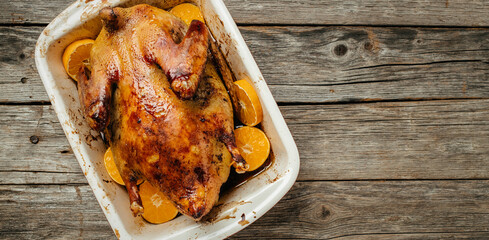 Wall Mural - Homemade baked duck with rosemary and oranges. Crispy whole roast duck. Thanksgiving or Christmas dinner. place for text, top view