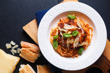 Food concept Homemade pasta Linguine meat bolognese sauce in a white ceramic pasta bowl on wooden board with black slate stone for copy space