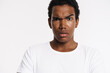 © Drobot Dean - Young black man dressed t-shirt looking at camera and frowning