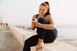 © Drobot Dean - Ginger young woman smiling and using cellphone during yoga practice