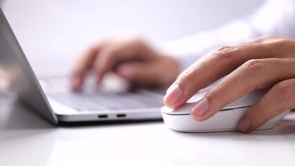 Fototapete - The male hand holds a computer mouse and typing laptop keyboard.