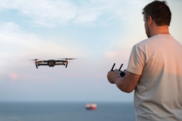 Wall Mural - man operating drone, filming ocean. drone operator monitoring ocean, fish farming.