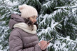 Outdoor winter portrait. Beautiful woman 45 years old talking on a cell phone in a snowy winter park.