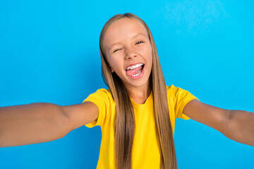 Poster - Photo of crazy influencer little lady make selfie wink eye show tongue wear yellow t-shirt isolated blue color background