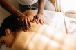 © Cavan Images - Hands of african american professional therapist giving back massage
