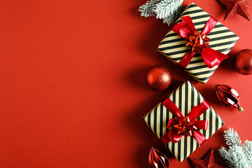 Christmas gifts and decorations on red background. Flat lay, top view, copy space. Christmas card mockup.