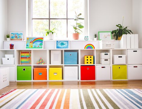 Fototapete - White nursery room with shelves and colourful boxes.