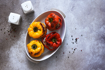 Wall Mural - Stuffed pepper. Paprika with rice and minced meat. Baked peppers on a concrete background..Top view.