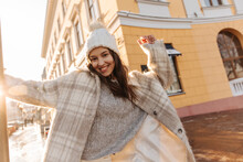 Cheerful Attractive Young Girl From Europe Is Actively Posing Outdoors With Smile On Her Face. Wearing Warm Winter Clothes, Stylish Brunette Woman Having Good Time.
