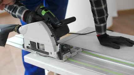 Wall Mural - A carpenter cutting a wooden board on the floor of the room