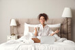© Pixel-Shot - Morning of young woman with cup of tea and laptop in bed