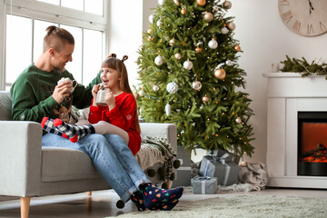 Wall Mural - Happy daughter and father with cups of hot cocoa and marshmallow at home