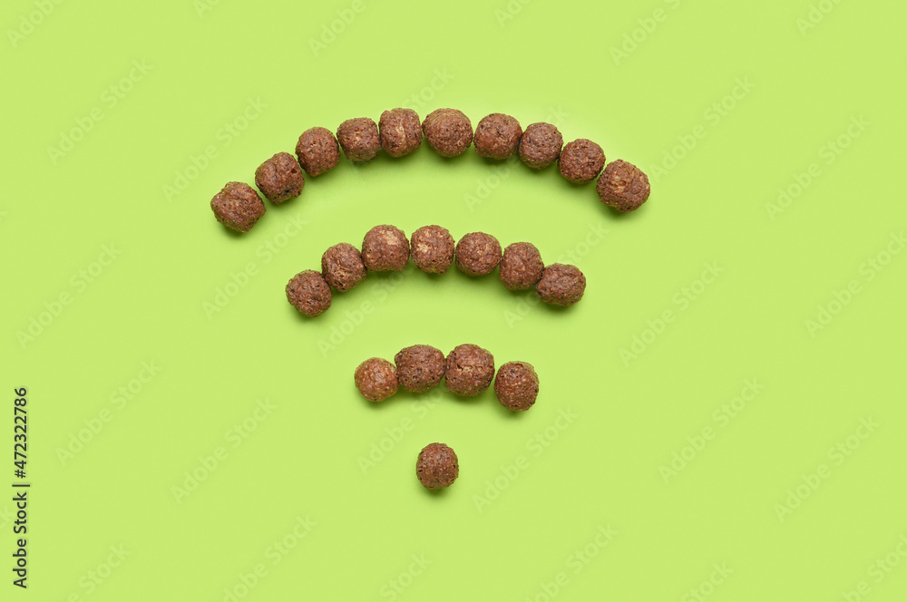 WiFi symbol made from chocolate balls on green background