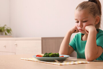 Canvas Print - Cute little girl refusing to eat her breakfast at home, space for text