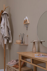 Poster - modern hallway interior with stylish furniture, table and wooden hanger for keys on beige wall
