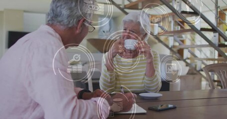 Sticker - Animation of network of connections with icons over senior caucasian couple at home