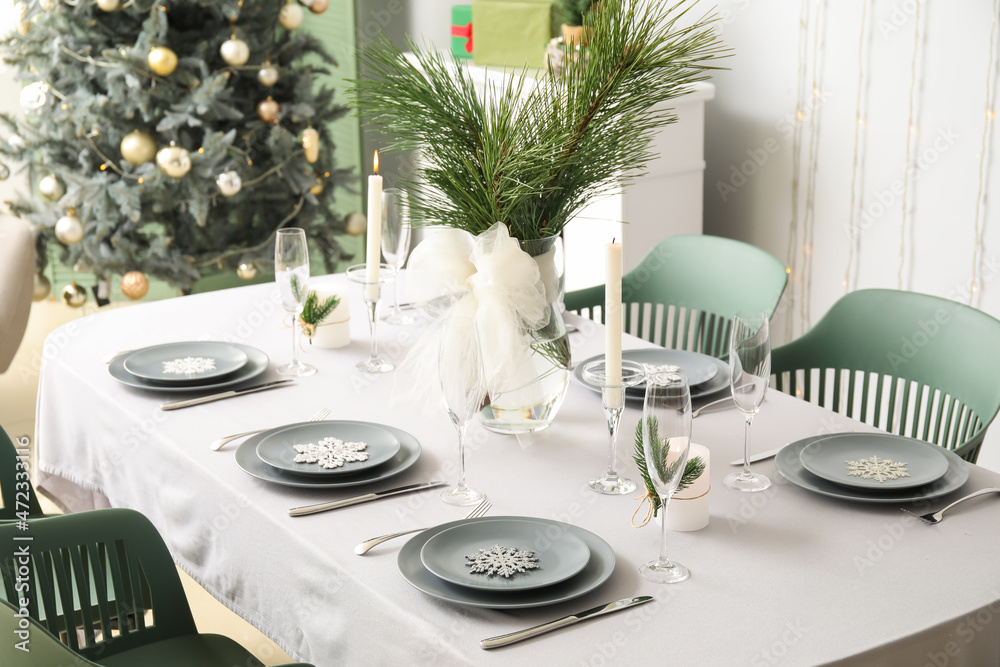 Dining table with beautiful setting for Christmas celebration in festive room