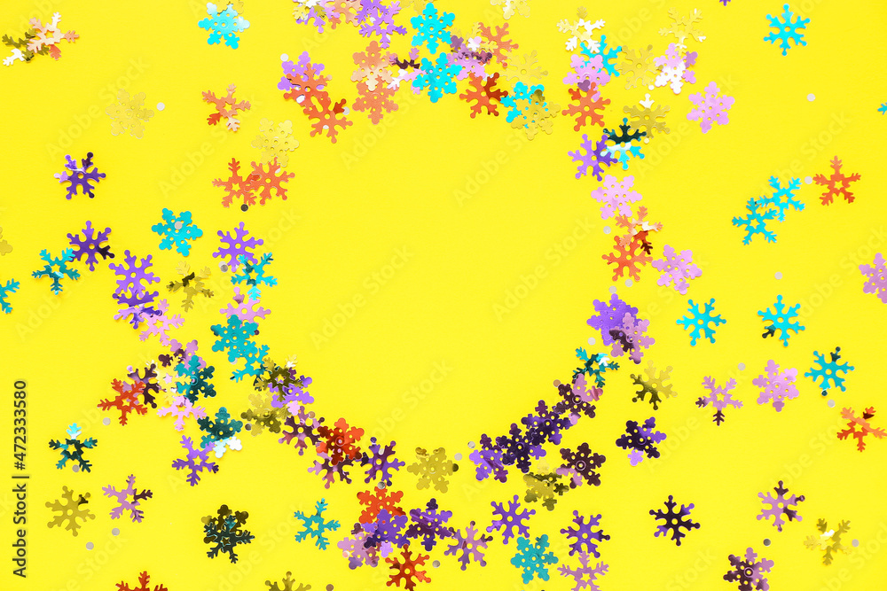 Frame made of colorful confetti on yellow background
