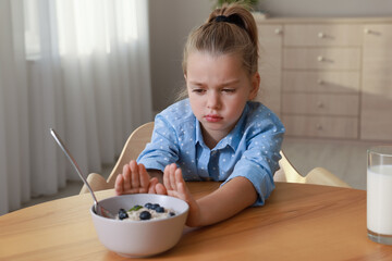 Canvas Print - Cute little girl refusing to eat her breakfast at home