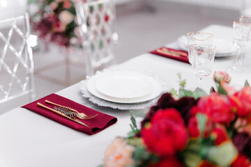 Wall Mural - Beautiful festive table setting with napkins of different colors. A luxurious dining set with cutlery, napkin, dishes and covered with a tablecloth in the restaurant. Gold plates and crystal glasses. 